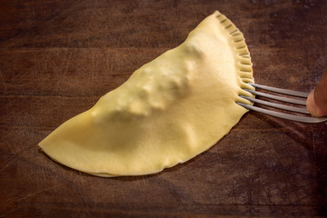 Traditional Brazilian food called pastel preparation with a fork