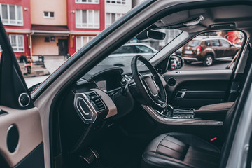 Fototapeta na wymiar Dark luxury car Interior - steering wheel, shift lever and dashboard. Car interior luxury. steering wheel, speedometer, display, seats