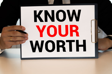 Businessman holding a card with text Know Your Worth