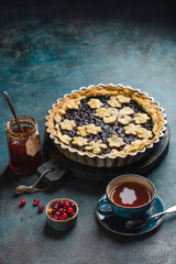 Tea party at the autumn table with berry pie and a cup of hot tea. Top view