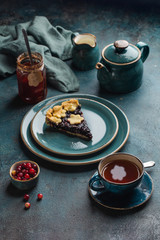 Tea party at the autumn tablewith a slice of berry pie and a cup of hot tea. Top view