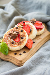 A healthy breakfast of pancakes, strawberries, chocolate, and honey