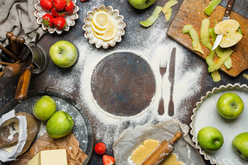 Variety of food products on the kitchen table. Pie making process, top view. Space for text