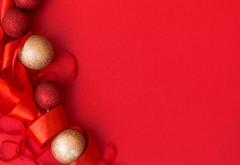 The concept of New year and Christmas. Red and gold Christmas balls on a red background, red ribbon