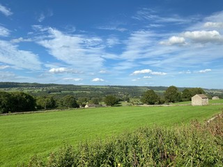 Landscape view of fields, and an old stone barn, in an extensive meadow in, West Witton, Leyburn, UK