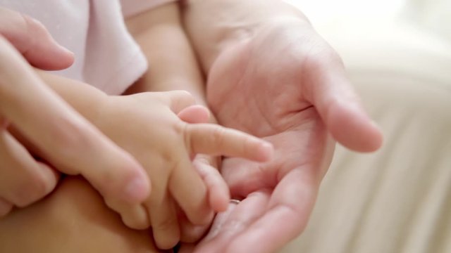 赤ちゃんの手を握るお母さん