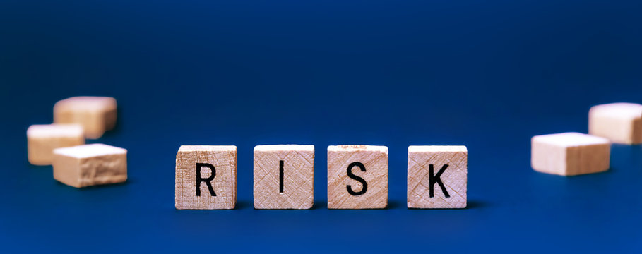 Word - Risk. Square wooden letters on a blue background