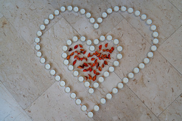 Tea candles arranged in the shape of a heart with read leafs in the middle | Celebrating anniversaries and wedding at home | Valentines day