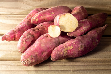 Red sweet potato pile on wooden background in Brazil