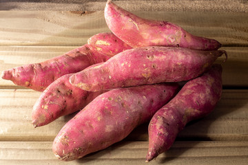 Red sweet potato pile on wooden background in Brazil