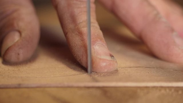 Man sawing piece of wood in an electric bandsaw