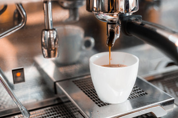 black coffee in white cup put on coffee maker