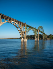 A side profile view of the Yaquina Bay Bridge  taken at sunrise during low tide in Newport Oregon in vertical orientation