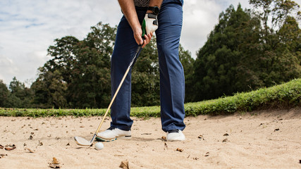 Professional golfer. hits the ball from the sand trap