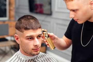 handsome male client has a haircut in a barbershop