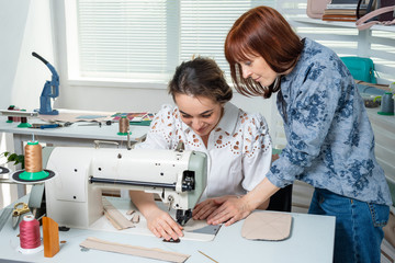 a mentor teaches a student to sew