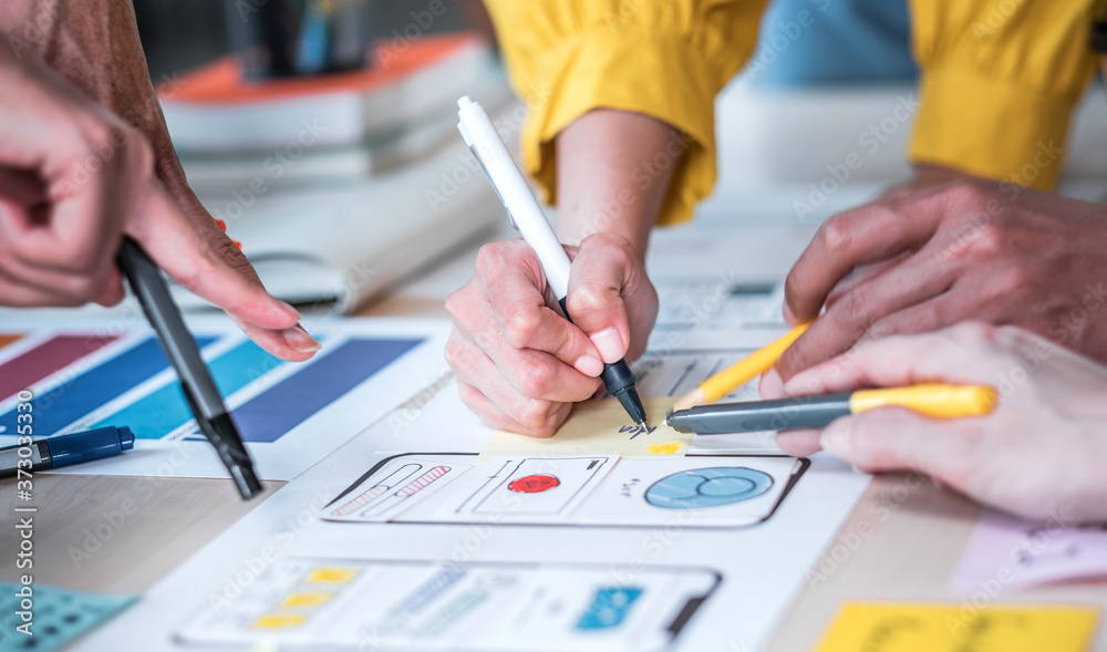 Aufkleber Close up hand ux developer and ui designer brainstorming about mobile app interface wireframe design on table at modern office.Creative digital development agency
