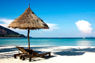 empty sunbeds on a tropical beach. Chairs on the sandy beach near the sea. Summer holiday and vacation concept for tourism. Beautiful beach