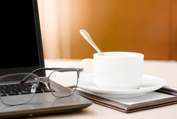 Working from home with laptop glasses pen and coffee cup hot in the morning. Workspace background composition with space for text. Enjoy love relax time during working at home with copy space.