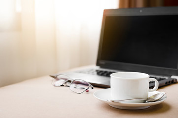 Working from home with laptop glasses pen and coffee cup hot in the morning. Workspace background composition with space for text. Enjoy love relax time during working at home with copy space.