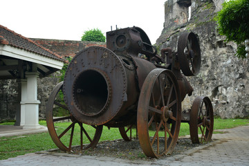 Baluarte De San Diego rusty locomotive train and parts display at Intramuros walled city in Manila, Philippines