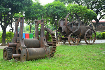 Baluarte De San Diego rusty locomotive train and parts display at Intramuros walled city in Manila, Philippines