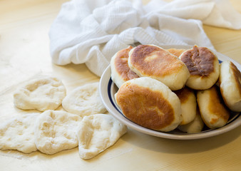 Homemade pies in a plate, baking dough.