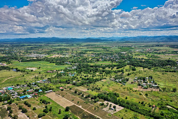 Fototapeta na wymiar This unique photo shows the landscape of Hua Hin in Thailand and in the background the green mountains with a slightly cloudy blue sky