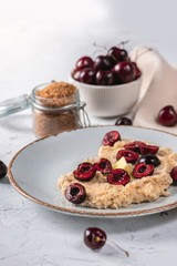 Fresh oatmeal with cherry and butter on light background