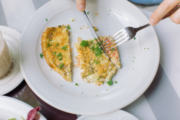 Close up of tasty omelet with bacon, vegetables and fresh greens . Breakfast concept.