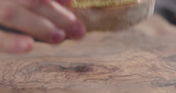 Slow motion man hand taker ciabatta slice with pistachio spread closeup