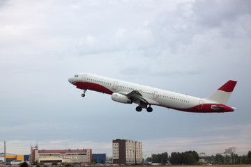 Passenger plane takes off from the airport runway. Side-view of aircraft