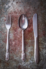 High angle shot of a fork, knife, and a spoon on a table