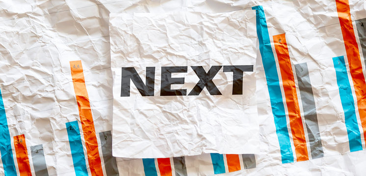 NEXT word text on the white memo note crupled sticker on chart background