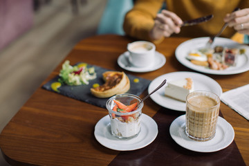 Varied breakfast in a cafe. Homemade granola, salad, pie and English breakfast served with coffee.
