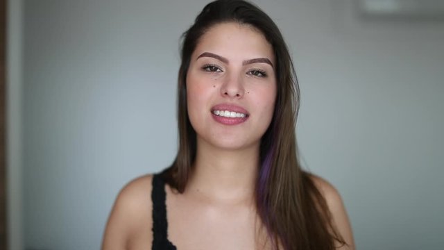 Beautiful young woman giving testimony. Pretty girl face talking to camera feeling happy