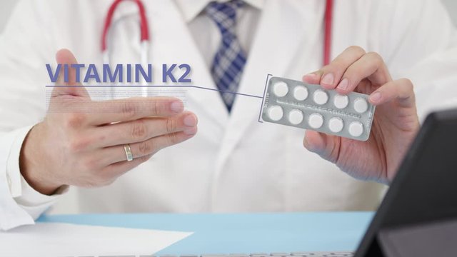 Vitamin k2 blister pack with tablets in doctor's hand