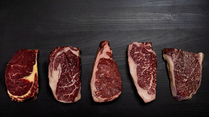Top view for variety of raw beef on black wooden surface. Ribeye, Black Angus Ribeye Grain Fed 200...