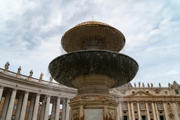 Piazza San Pietro in Rome, fountain with the dome and a detail of the church.