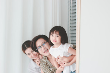 Happy family having fun in the bedroom. Father, mother, and daughter spending time together, playing hide and seek, parents and kid having good memory together at home