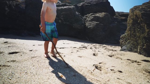 Preschooler playing near rocks on the beach