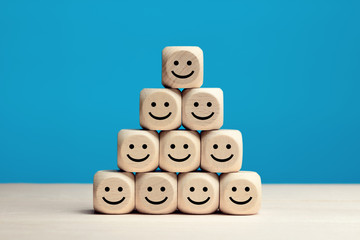 Smiley faces on wooden cubes. Business service rating, customer satisfaction or teamwork concept.