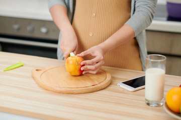Young pregnant woman in the kitchen at home healthy snack
