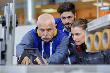 professional electrician with students on construction site