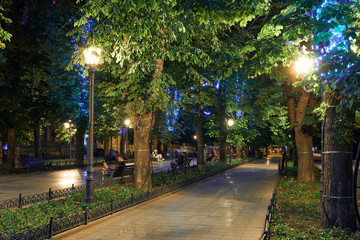 night view of Primorsky boulevard in Odessa city, Ukraine. Beautiful city Park and street illumination, walking people
