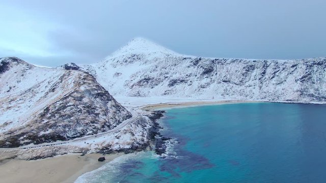 lofoten snow covered haukland beach  aerial view drone flying forward over coast winter time