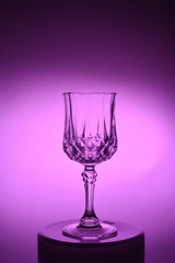 Wineglass on the light background. Fine cristal glassware concept. Vertical, toned in pink