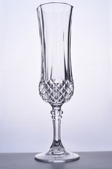 Glass goblet with space for text on a gray background. One wine glass on a gray background. One transparent glass for chompian on a white background
