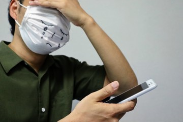 スマホを見て悲しむ男性のクローズアップ