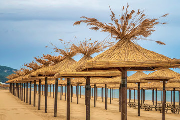 Beauty wooden umbrellas of empty sandy beach